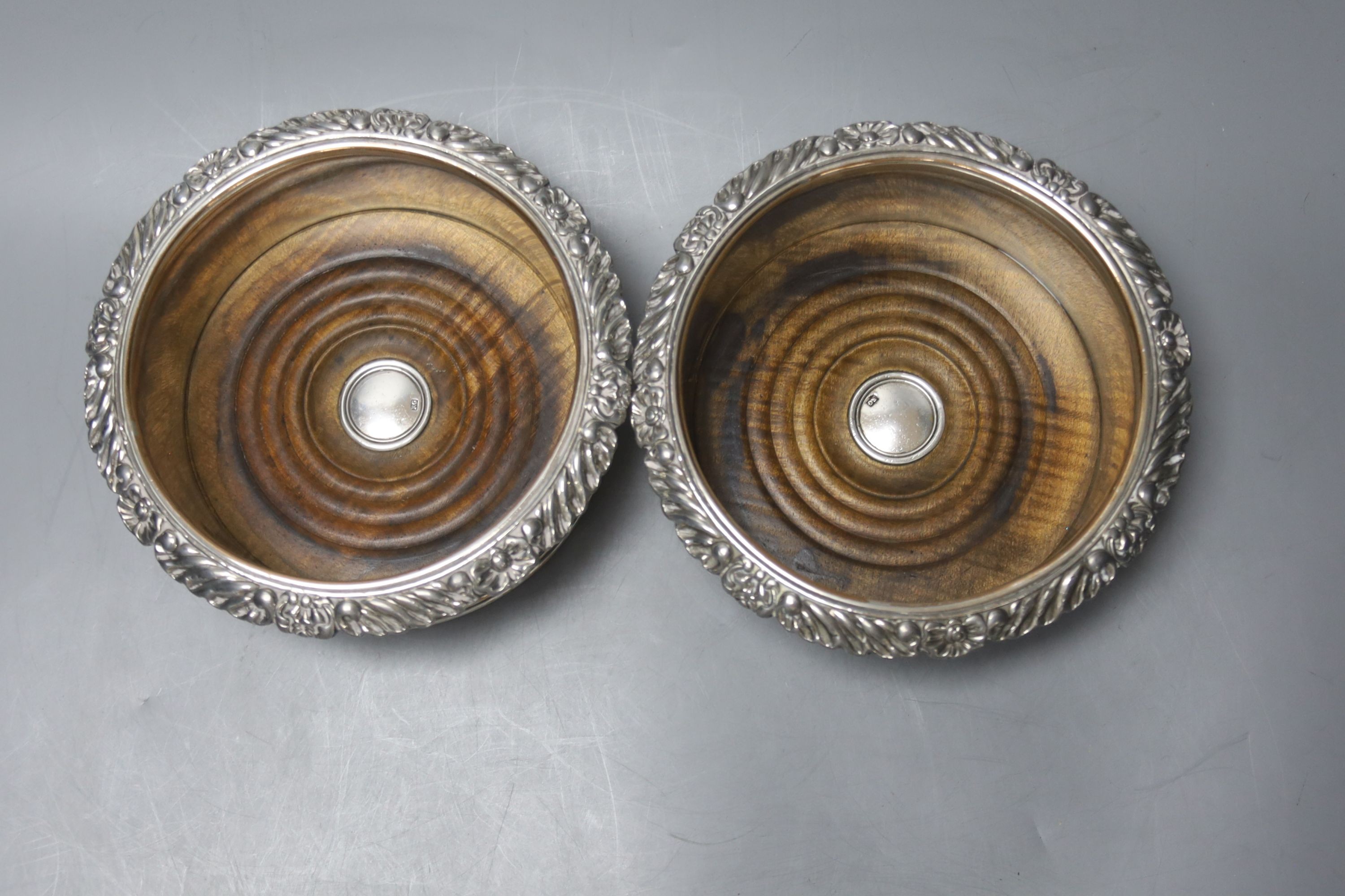 A pair of silver plated coasters with cut glass decanters. 20cm